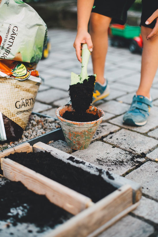 Gartenarbeit: Mit frischer Erde wird ein Blumentopf befüllt (Bild: pexels.com /Markus Spiske)