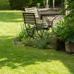 gepflegte Rasenfläche mit Sitzecke im Garten